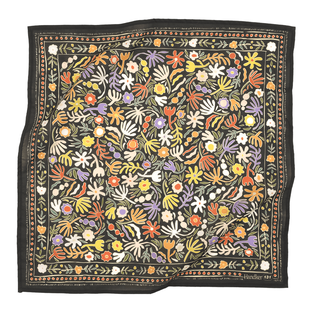 A multicolored bandana with a floral pattern, predominantly in shades of blue and green, laid out flat.