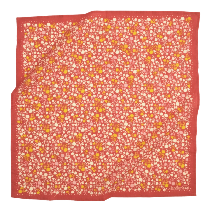 A multicolored bandana with a floral pattern, predominantly in shades of blue and green, laid out flat.
