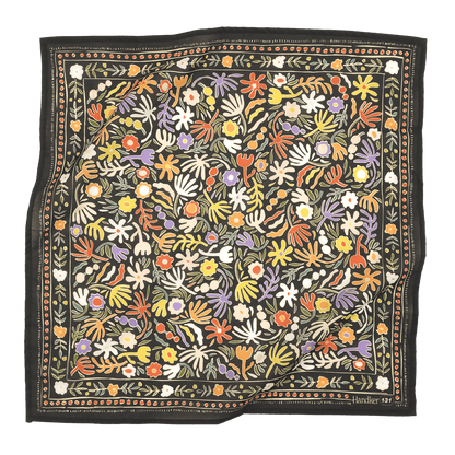 A multicolored bandana with a floral pattern, predominantly in shades of blue and green, laid out flat.