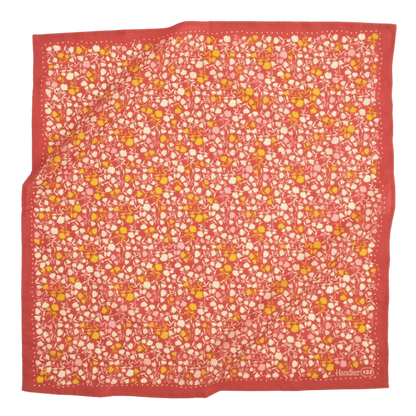 A multicolored bandana with a floral pattern, predominantly in shades of blue and green, laid out flat.